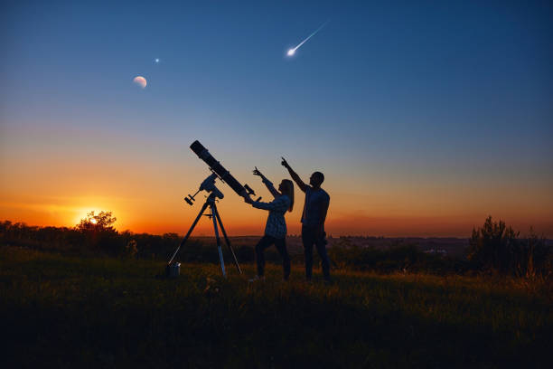 istock Couple stargazing together with a astronomical telescope. 1370648588