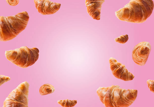 istock Croissants levitating or flying on pink background. Levitation, fly scene 1370650374