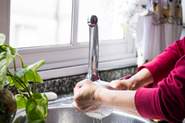 istock woman washing cup in kitchen sink 1370650874