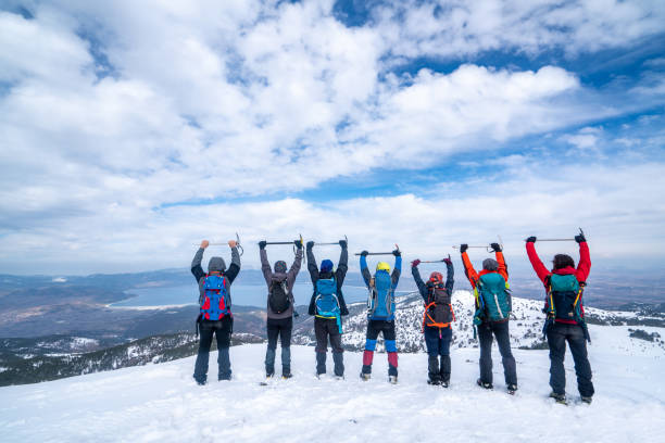 la squadra di arrampicata alpina celebra il proprio successo agitando la piccozza in aria sulla vetta della montagna d'alta quota con lo sfondo del lago salda - turkey extreme terrain snow nature foto e immagini stock