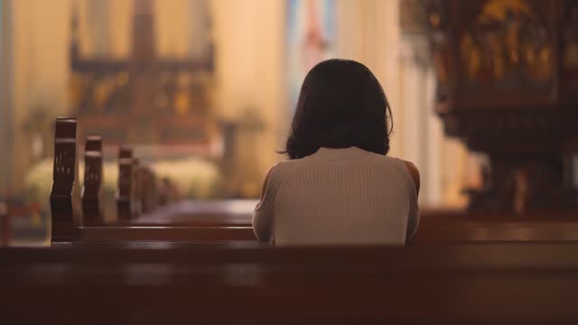 Religious Christian woman praying in church