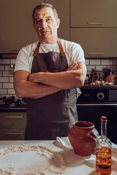 istock muscular man stands in kitchen, ingredients for making dough are on table 1370655564