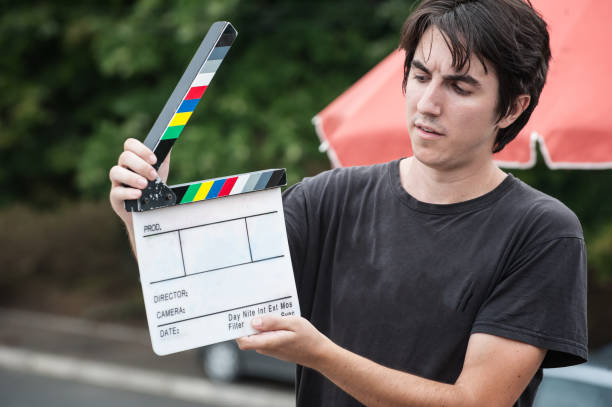 istock Man holding a clapper board in front of the camera 1370657262