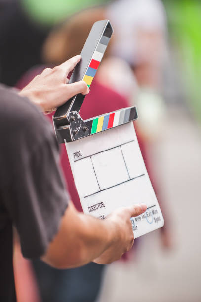 Man holding a clapper board in front of the camera