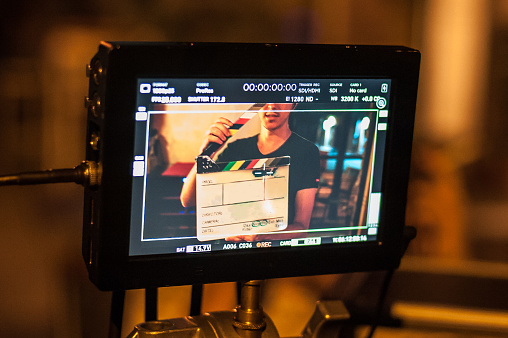 Filming on location. Man holding a clapper board in front of the camera, the filming process. Scene on location