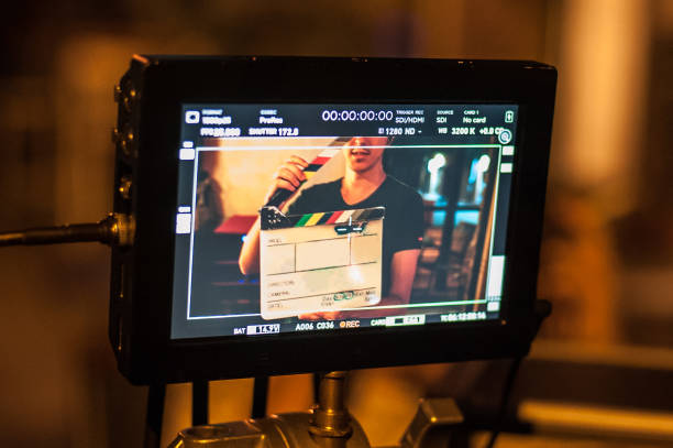Man holding a clapper board in front of the camera Filming on location. Man holding a clapper board in front of the camera, the filming process. Scene on location film set stock pictures, royalty-free photos & images