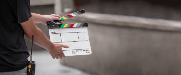 istock Man holding a clapper board in front of the camera 1370657300