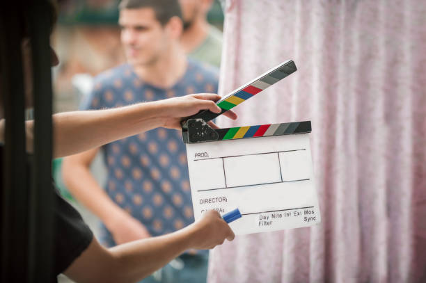 istock Man holding a clapper board in front of the camera 1370657431