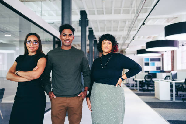 istock Three businesspeople standing together in an office 1370659533
