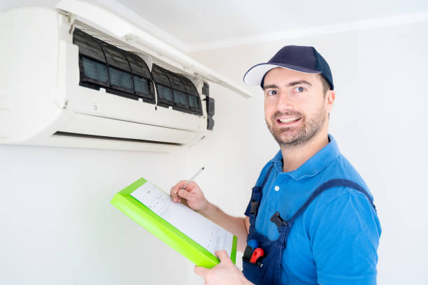 istock Technician with clipboard looking at air conditioner for installation quote 1370660007