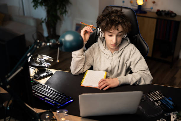 istock Smart young boy uses laptop to learn, records useful information. distance learning, e-Education, e-Learning. Portrait of a boy doing his homework 1370660158