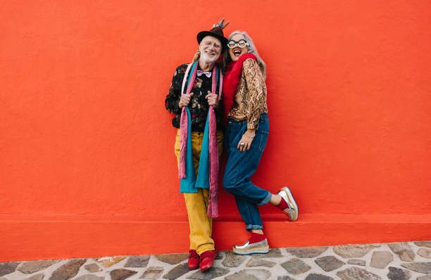 istock Senior couple laughing cheerfully against a red wall 1370660964