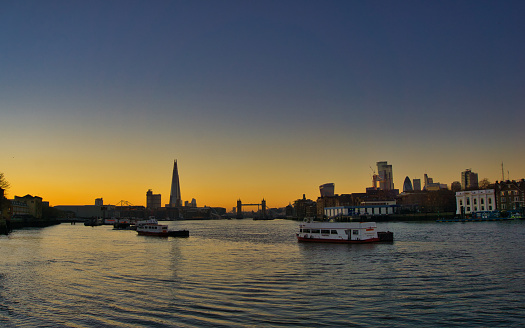 London Sky line at sunset. Image of Tower Bridge, the Shard, St Pauls, Fenchurch street, the Gurkin, and the River Thames  under a clear golden sky sunset.  Image taken from south bank of the river Thames looking down river