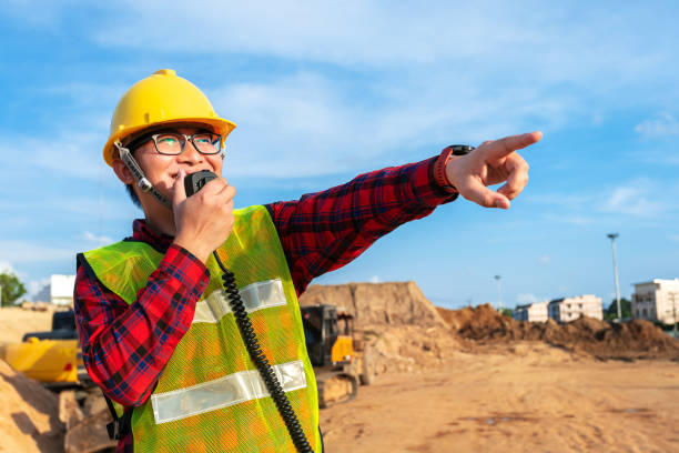 istock asian technician civil engineer talk with team by walkie talkie and point at inspection survey point for transport construction work project with excavator on engineering site background 1370661603