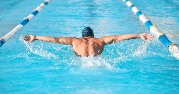 foto de un joven atleta masculino irreconocible nadando en una piscina olímpica - acontecimiento deportivo internacional fotografías e imágenes de stock