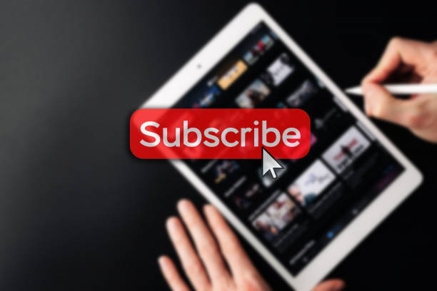 istock Subscribe now. Online video subscription red button. Internet service on laptop digital tablet blured technology background. Streaming video. Communication network. 1370663980