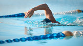 Shot of an unrecognizable young male athlete swimming in an olympic-sized pool