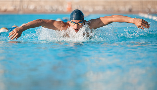 Swimmer enters the water in a side view with a dive.