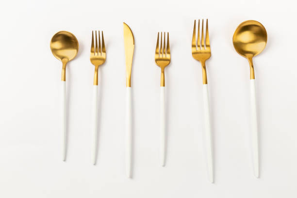istock gold spoon fork and knife on a white background 1370664909
