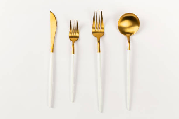 istock gold spoon fork and knife on a white background 1370664924