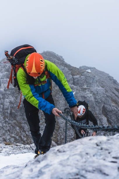 istock Hikers with helmet climbing along the mountain ridge 1370665006