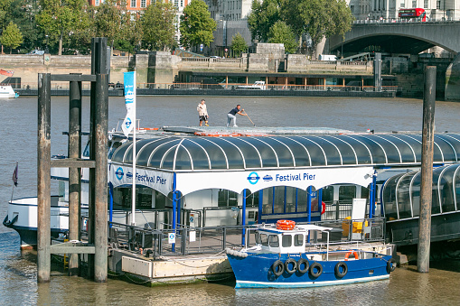 Manual Workers cleaning the surface at Festival Pier on Thames River, London