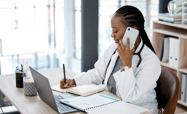 istock Shot of a young doctor making a phone call while planning 1370667620