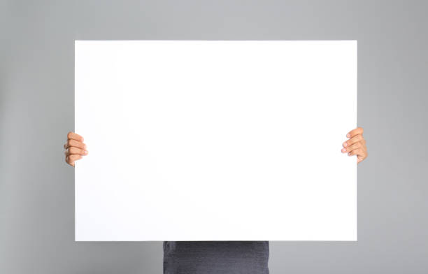 istock Man holding white blank poster on grey background. Mockup for design 1370668172