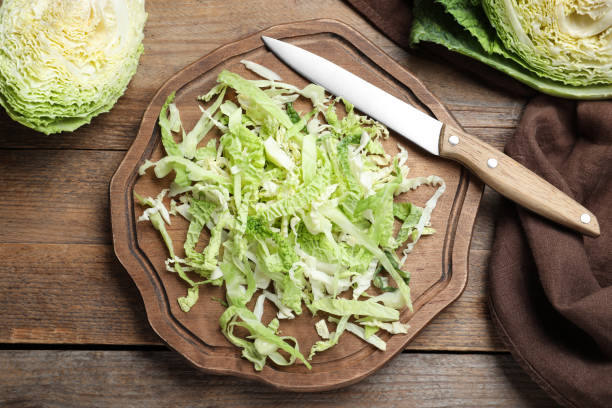 istock Cut fresh savoy cabbage on wooden table, flat lay 1370668268