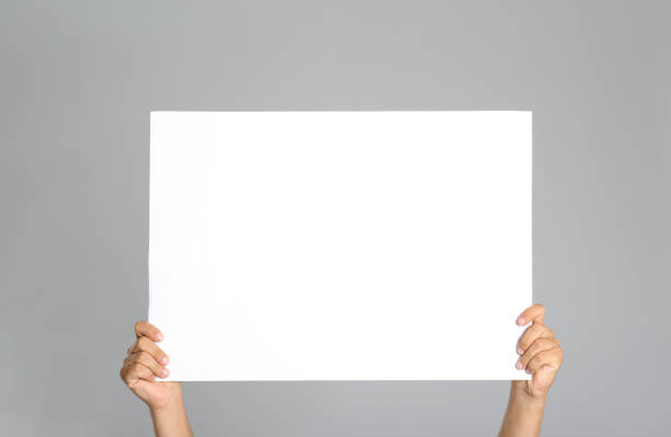 istock Man holding white blank poster on grey background, closeup. Mockup for design 1370668405