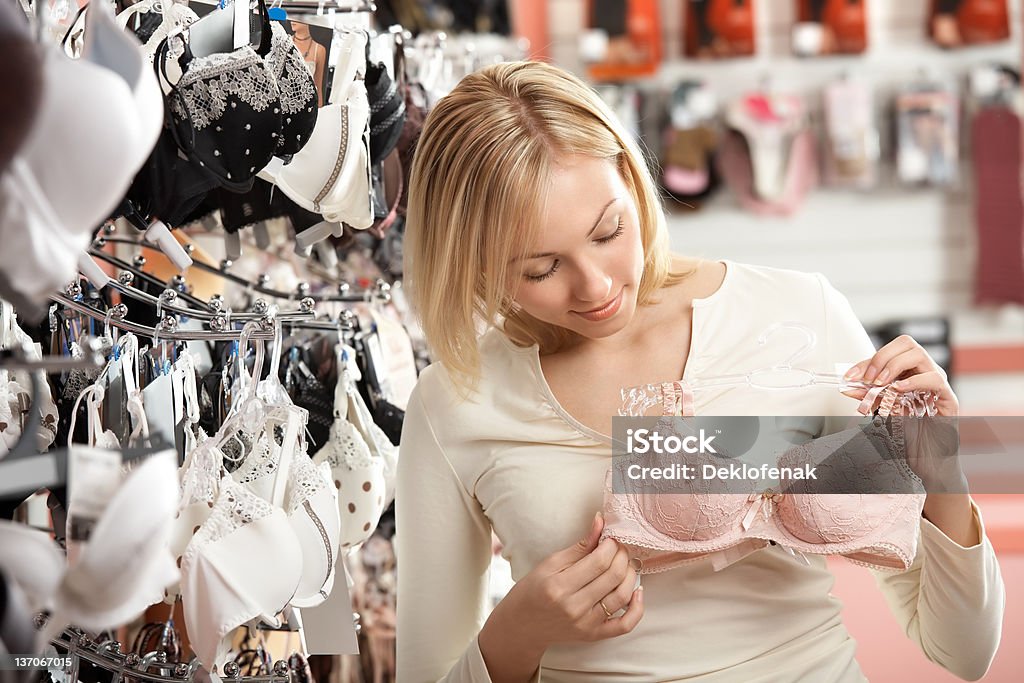 Underwear choice The woman considers a brassiere in shop Adult Stock Photo