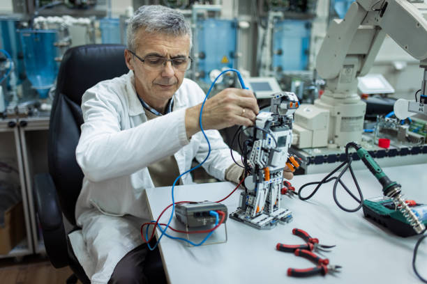 istock Mature male engineer examining robot in mechanical laboratory 1370670851