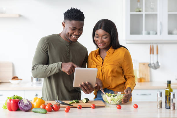 istock Online Recipe. Happy Black Spouses Using Digital Tablet In Kitchen While Cooking 1370672338