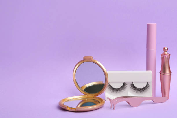 istock Magnetic eyelashes and accessories on violet background. Space for text 1370672505