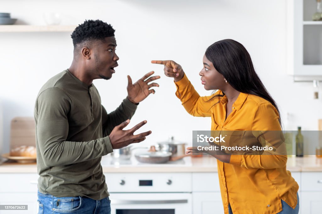Lovers Fight. Portrait Of Andry Black Couple Emotionally Arguing In Kitchen Lovers Fight. Portrait Of Andry Black Couple Emotionally Arguing In Kitchen, African American Spouses Screaming At Each Other, Suffering Problems In Relationship Or Marital Crisis, Side View Arguing Stock Photo