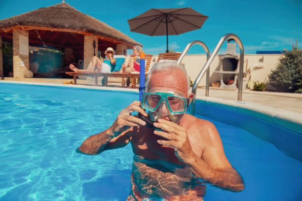 istock Senior man snorkeling in the swimming pool 1370673733