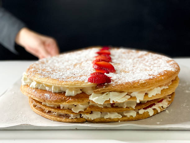 Human hand presenting homemade puff pastry cake with cream and strawberries to celebrate Valentine’s Day Human hand presenting homemade puff pastry cake with cream and strawberries to celebrate Valentine’s Day deli pie stock pictures, royalty-free photos & images