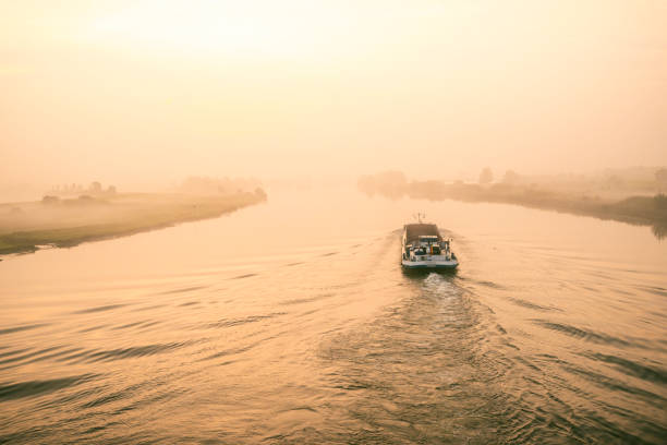 Ship carrying bulk goods in a sunrise over the river IJssel during a beautiful fall morning in the IJsseldelta region in Overijssel, The Netherlands.