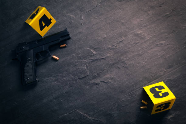 istock Bullets, gun and crime scene markers on black slate background, flat lay. Space for text 1370677611