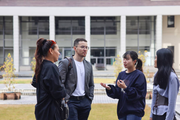 istock Graduate students enjoying talk at college campus 1370678418