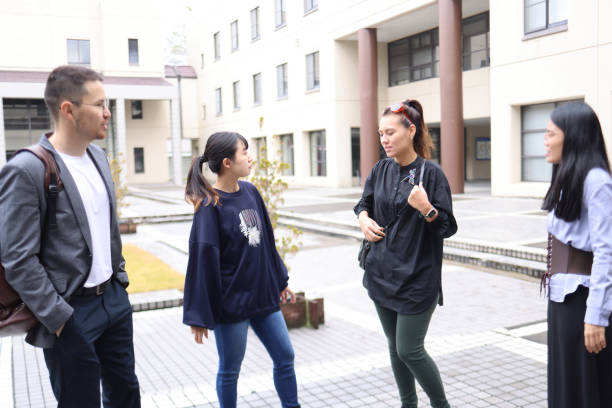 istock Graduate students enjoying talk at college campus 1370678701
