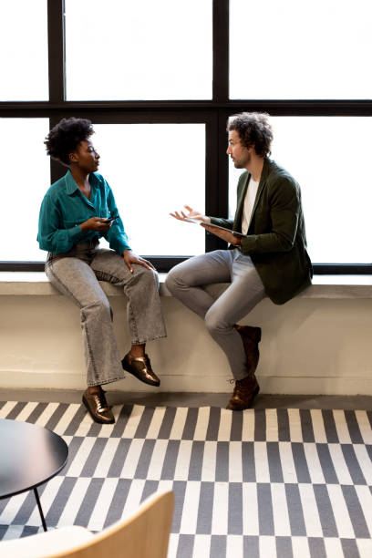 istock Two young attractive coworkers having a casual meeting 1370678808