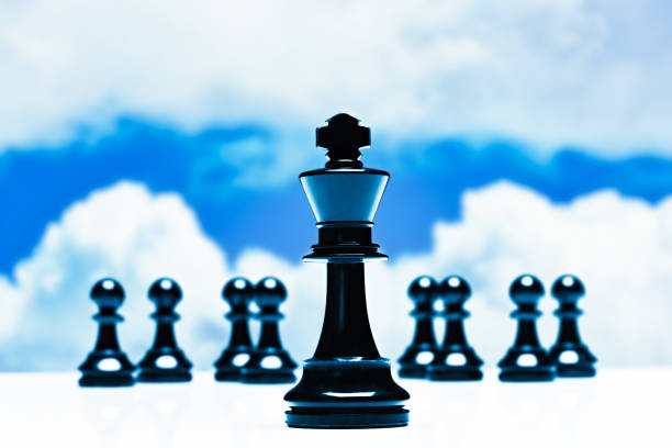 Leadership concept with chess king, pawns and sky.