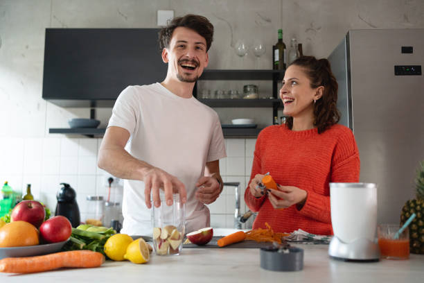 istock Healthy couple peeling fruit and vegetables for smoothie 1370681080