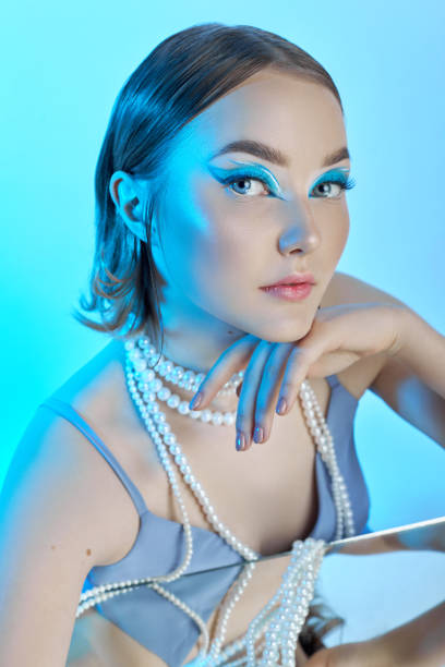 Beauty portrait woman makeup blue arrows eyes, beads jewelry around her neck, blue dress, woman at table with milk. Art makeup Professional makeup and cosmetics face. Sophisticated art portrait style retrato de belleza mujer maquillaje azul flechas ojos, cuentas joyas alrededor de su cuello, vestido azul, mujer en la mesa con leche. maquillaje artístico maquillaje profesional y cosmética facial. sofisticado estilo de retrato artístico