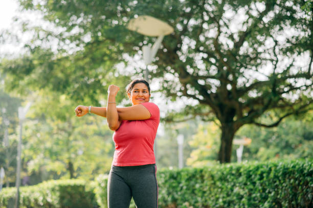 Woman warming up body, stretching arms.