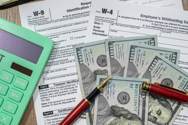 istock Form w4, w9 is empty to fill with money dollars on the table. 1370682703
