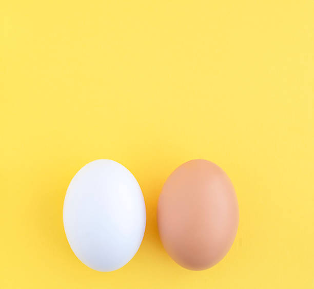 istock Food. Two Easter eggs white and brown on a yellow background, close-up. copy space. 1370684267