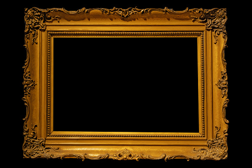 Empty gold ornate picture frame with black background