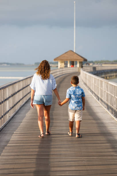 istock Mother and son on a runway holding hands 1370690227
